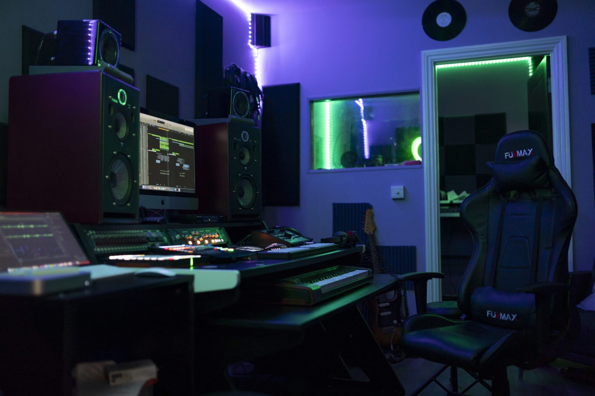 A music studio with a keyboard and speakers.