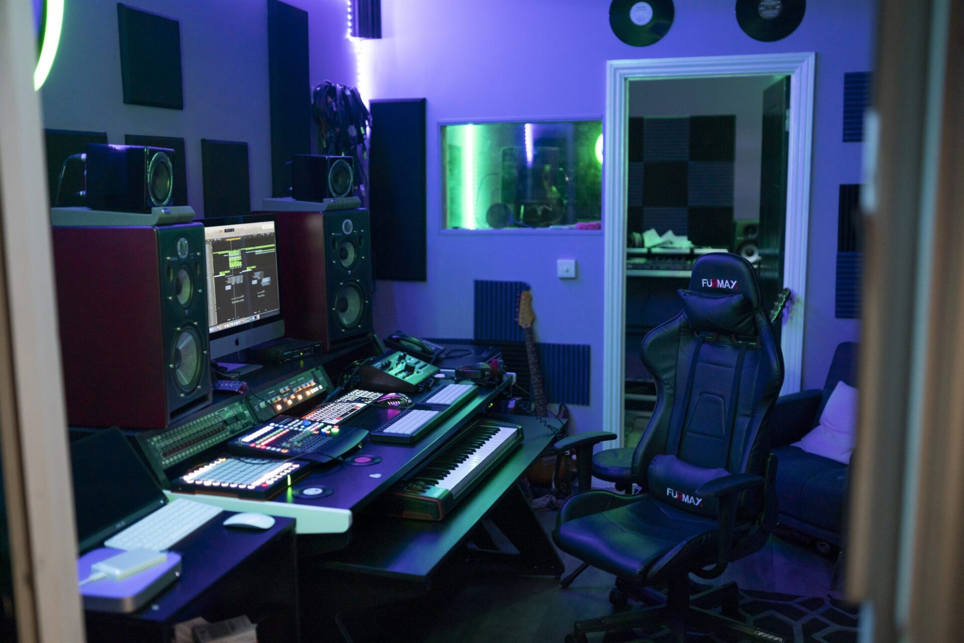 A recording studio with a computer desk and lighting.