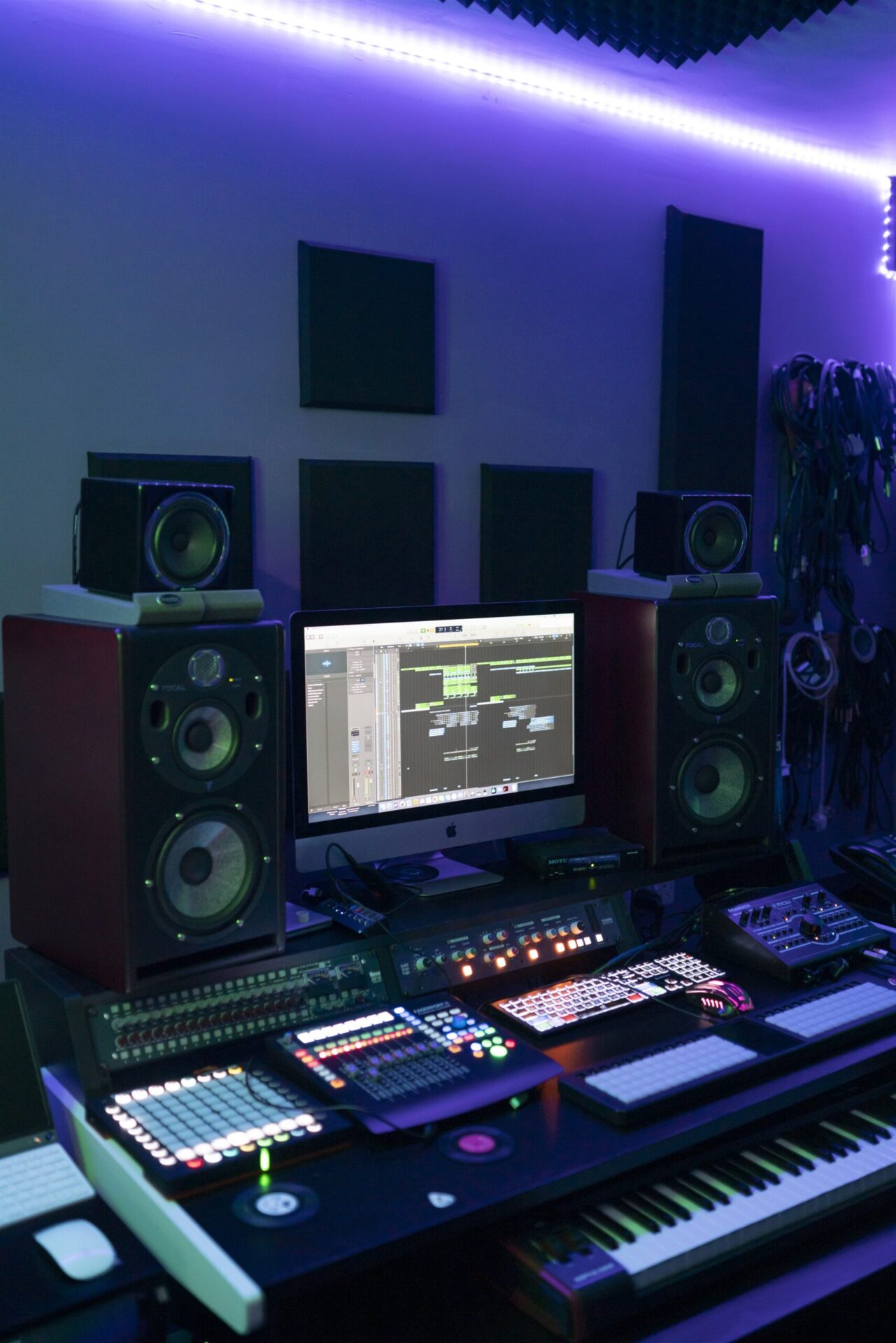 A recording studio with a keyboard and monitors.