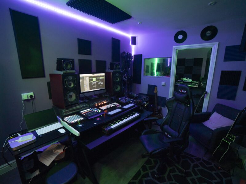 A recording studio with a desk and lighting.