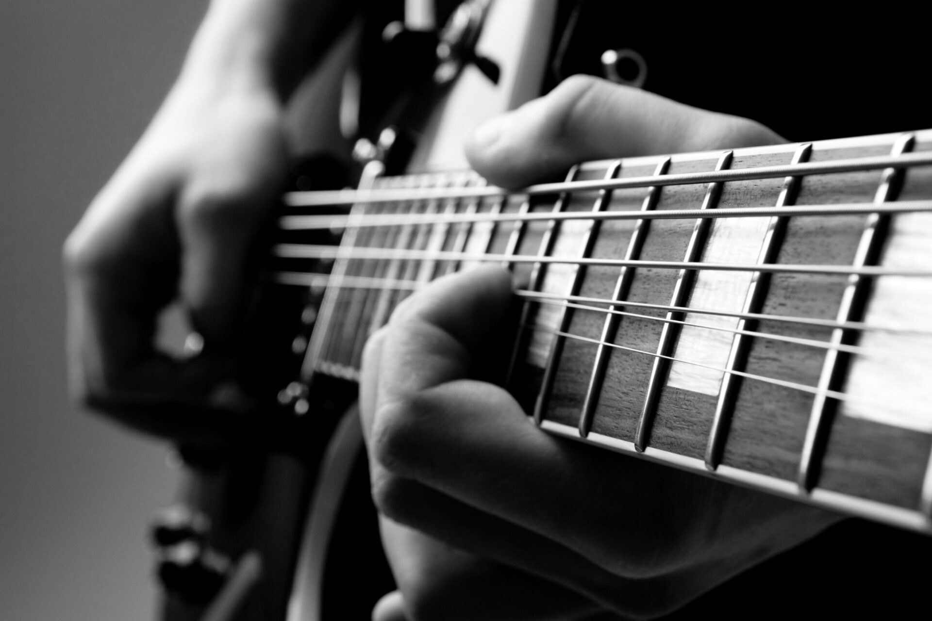 An Experience Day capturing someone playing an electric guitar in a black and white photograph.