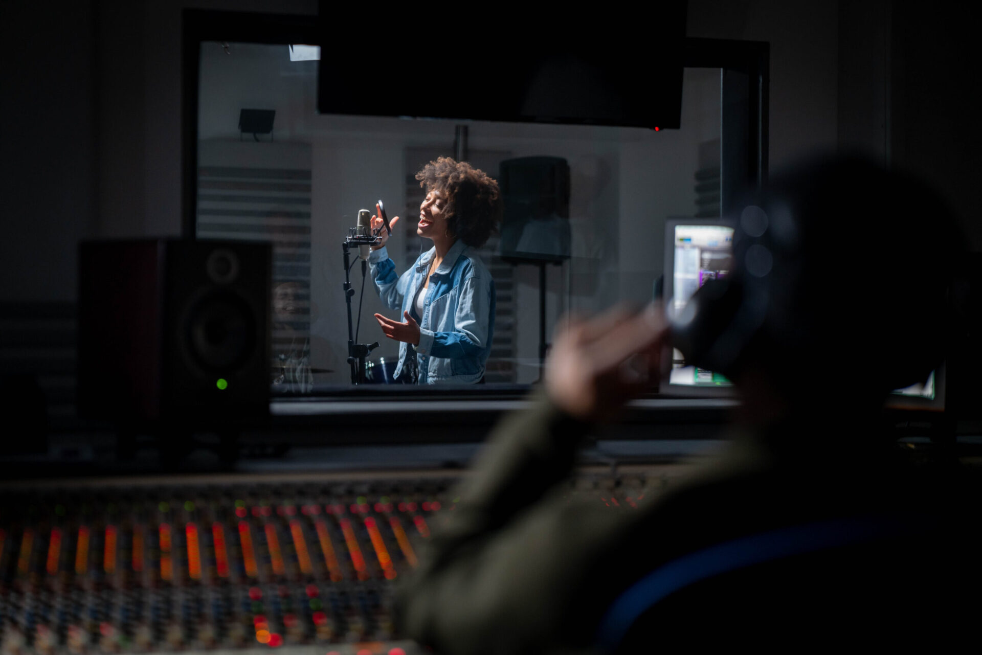 A woman is demo recording in a studio.