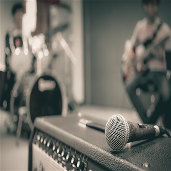 A microphone is capturing sound from a guitar amplifier during a demo recording.