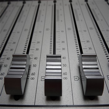 A close up of an audio mixing board providing Orb Music Studio services.