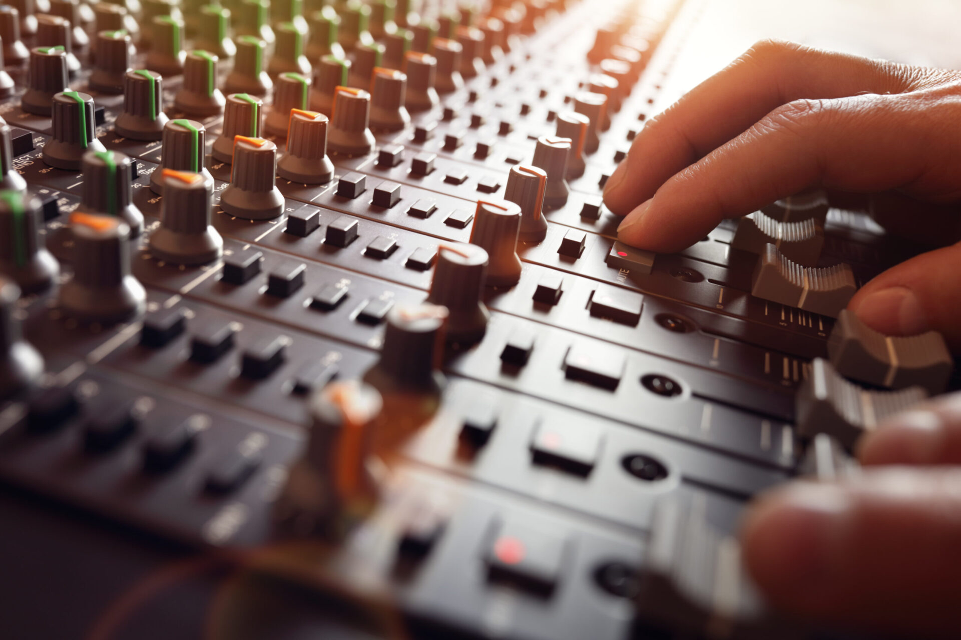 A person is partying while working on a mixing board.